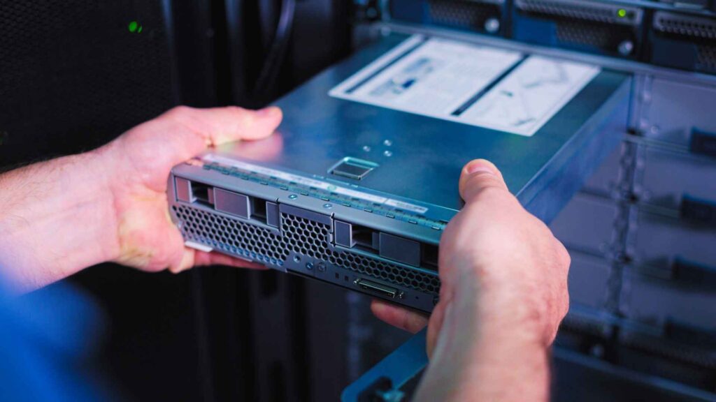 hands placing a server into a server rack hardware rentals