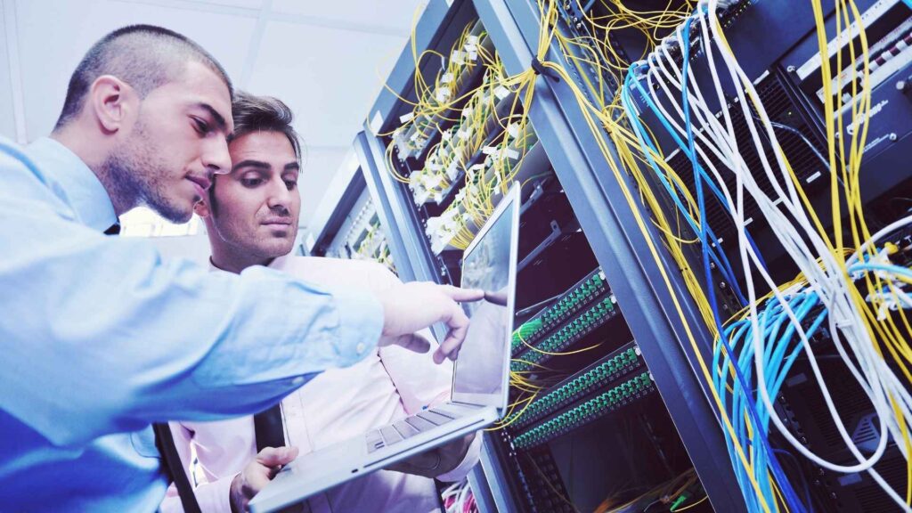 two business men with hardware rental server pointing at laptop