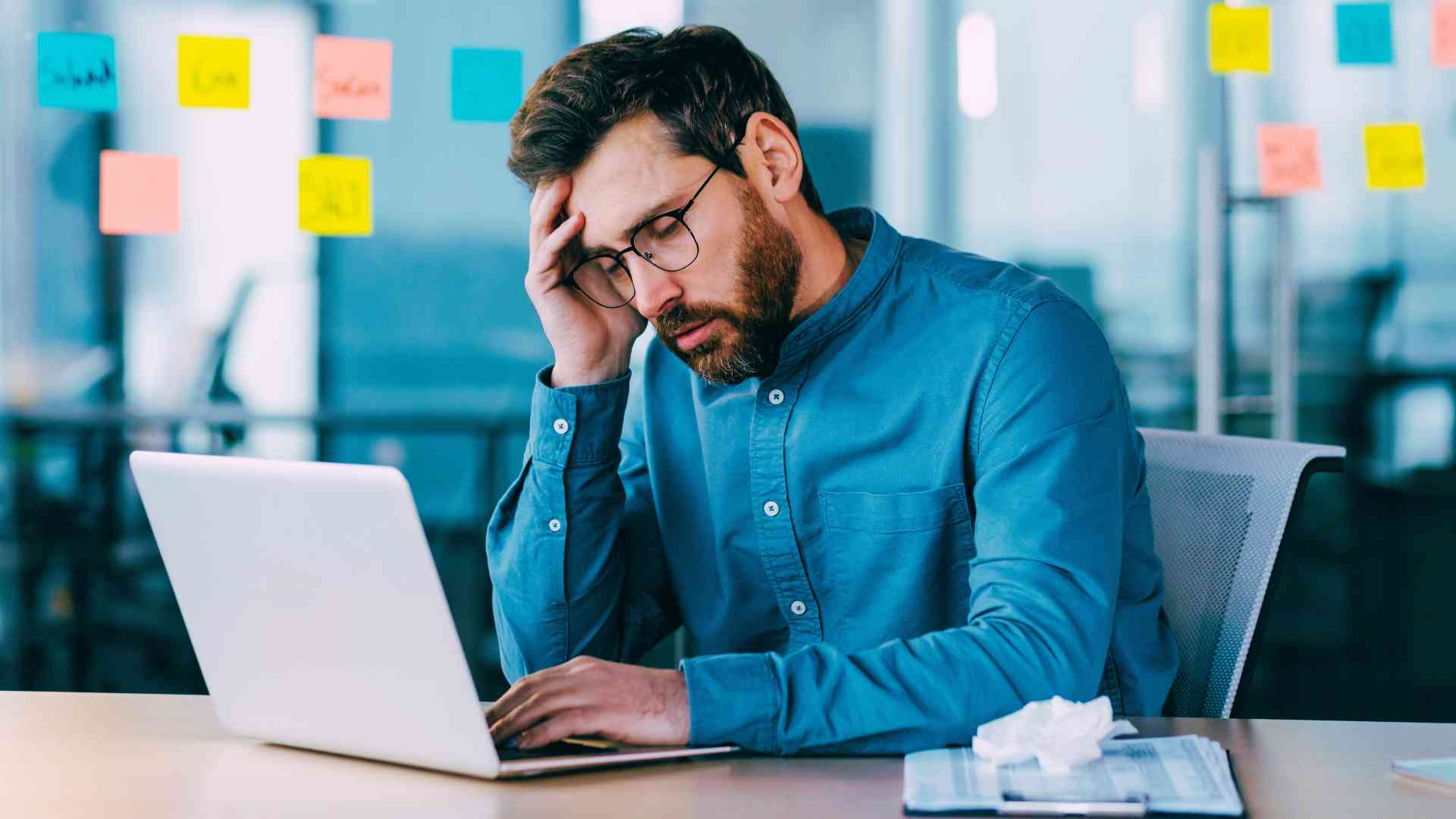 business man frustrated looking at his laptop stressed about impacts of IT downtime