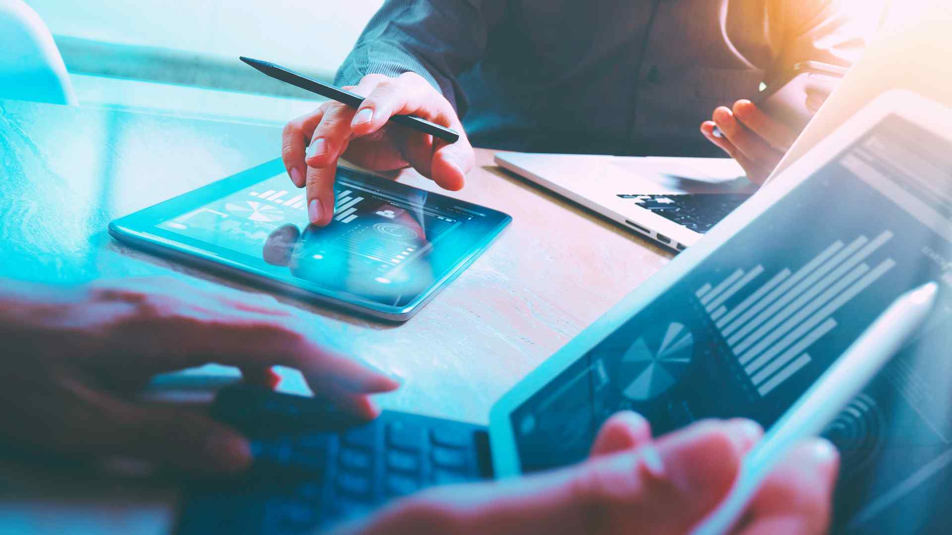 two people looking at bars and graphs on tablet devices about notifiable data breaches scheme