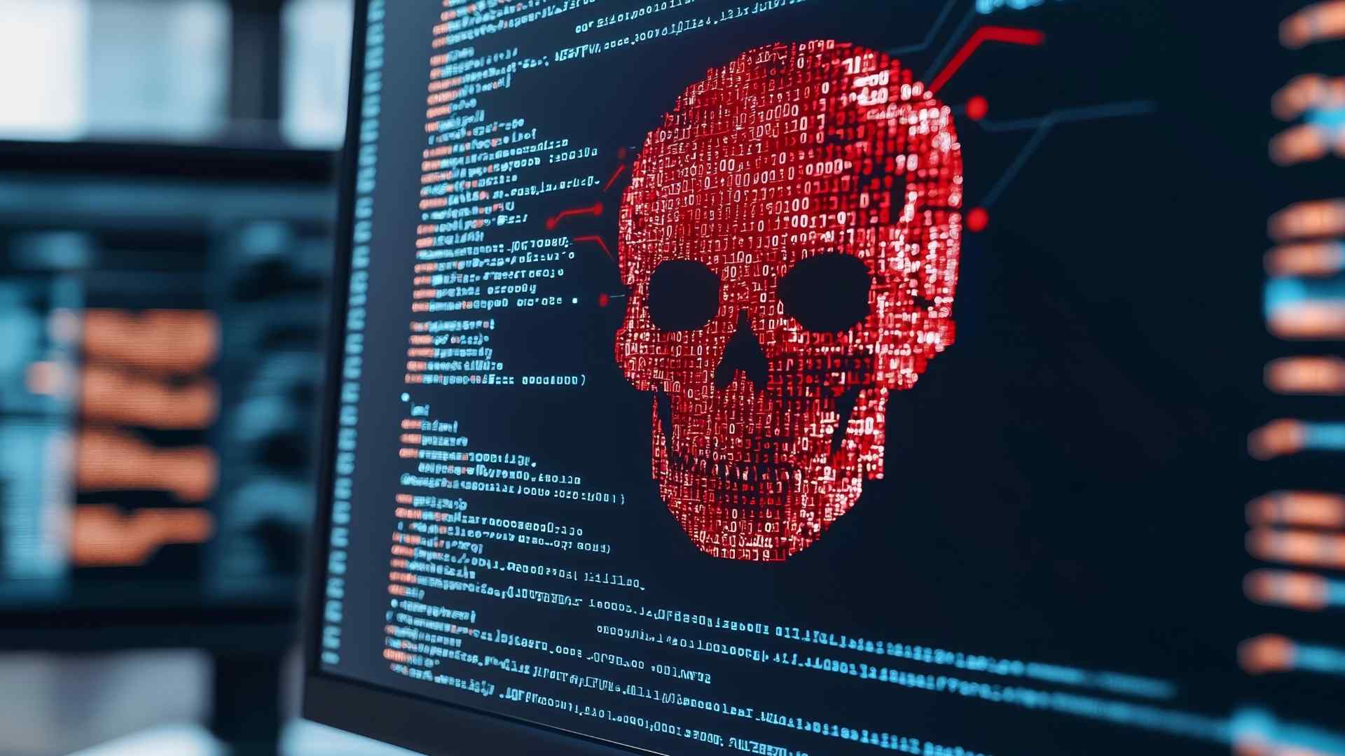 computer screen with code written and in the shape of a red skull from a cybercriminal