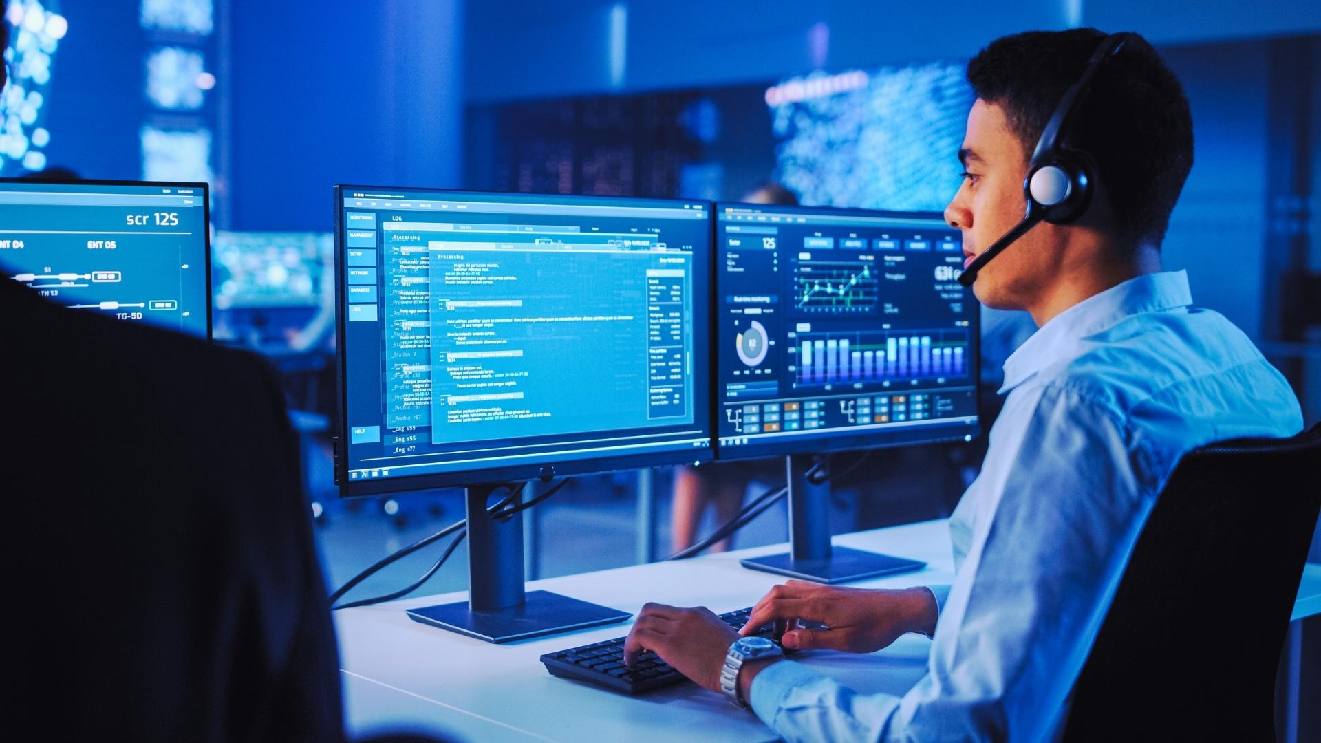 IT service management worker looking at computer providing IT support in office space