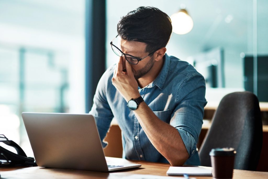 business man looking frustrated at laptop after trying to do DIY IT