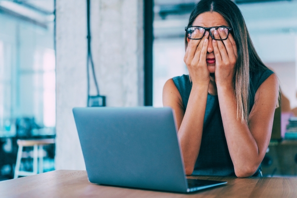 business woman looking frustrated and stressed working on laptop