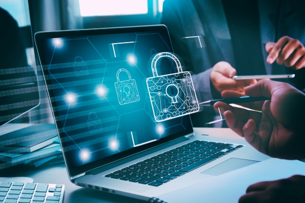 laptop with cybersecurity padlock graphic popping out off screen