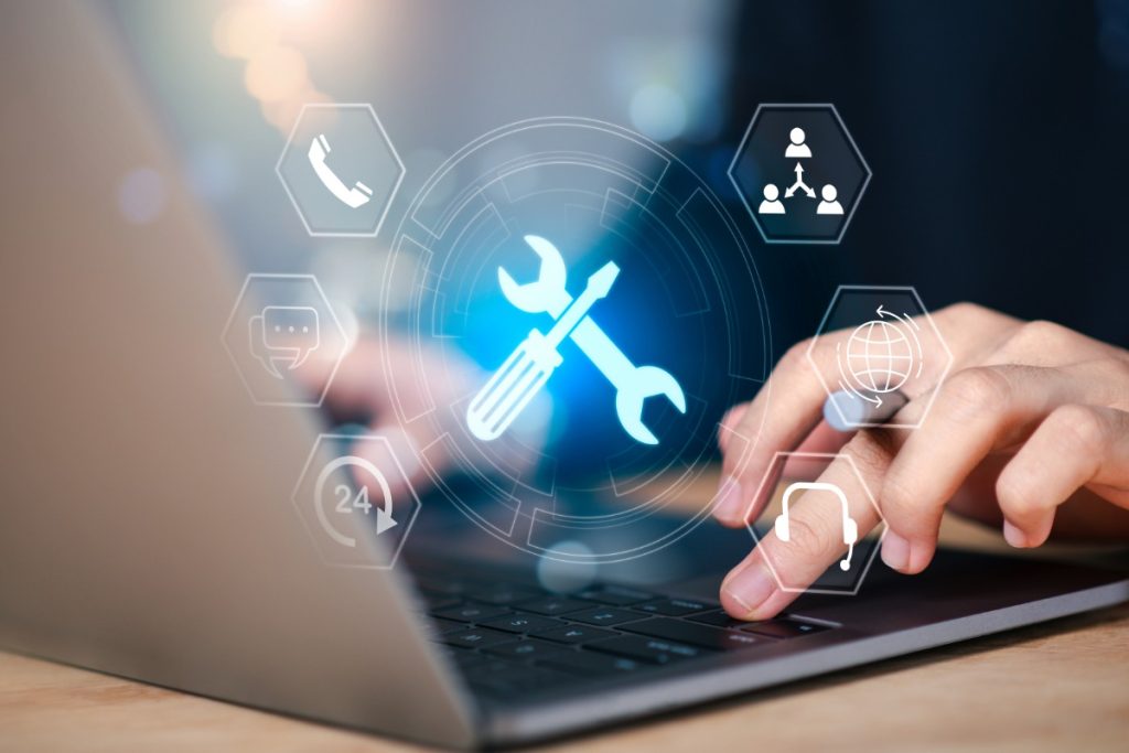 person typing on laptop keyboard with a settings icon for managed IT services
